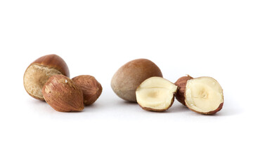 Whole hazelnuts scattered on a clean white background, showcasing their natural texture and rich...