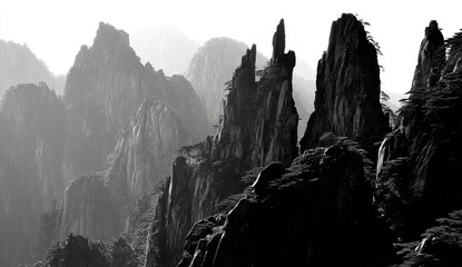 A dramatic black and white landscape captures towering, jagged peaks and misty mountain ranges.