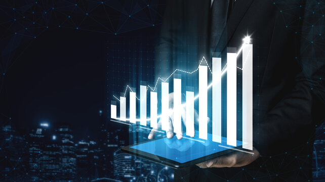 A businessman holds a tablet displaying a 3D growth chart against a cityscape backdrop, symbolizing financial success and modern technology in business analytics. Impute