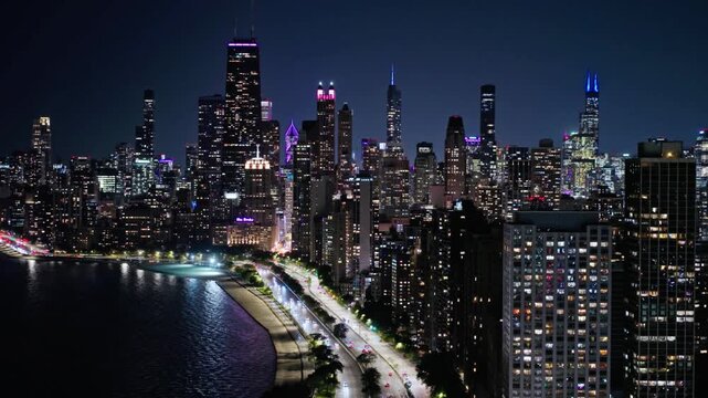 Chicago skyline glows with city lights at night along lake michigan