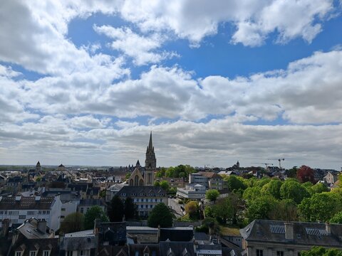 Panoramic view of city with church and green trees under blue sky - Powered by Adobe