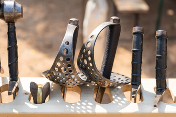 Medieval swords displayed on wooden rack at reenactment event
