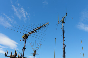 Various military antennas, transmitters and receivers for radio communication and transmission. Equipment, devices and technology used by signal corps. Blue sky as copy space.