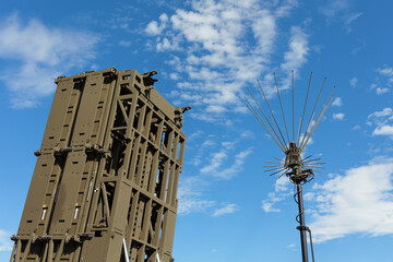 Anti aircraft defense system. Ground based surface to air missile. Military equipment to defend and protect agaisnt aerial threat. Device and blue sky with white clouds.