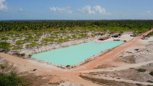 Aerial view of a turquoise lagoon surrounded by sand and lush vegetation