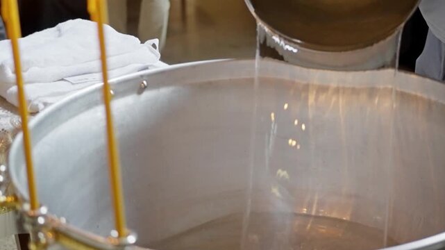 Aluminum tub with saint water for a baptism of babies in interiors.