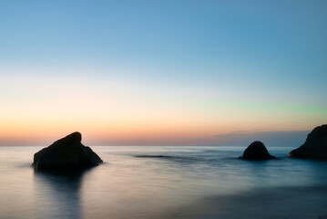Close up view of the Black Sea at sunset in Georgia with rocks in the water, perfect for travel, tourism, and nature themes.