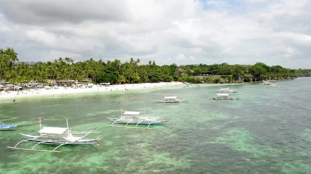 Boats rest in the clear turquoise waters off the coast of a tropical island