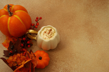 Colorful autumn decoration with pumpkins and dessert on a textured surface