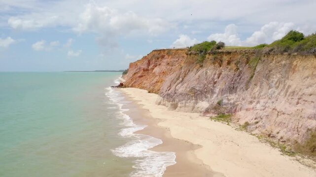People enjoy the beach near the cliffs on a sunny day in tambaba, brazil