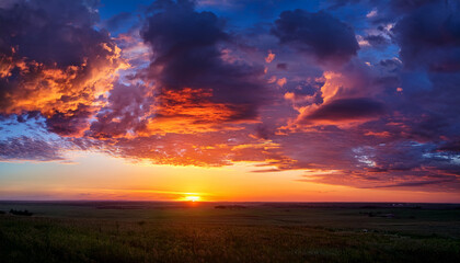 Obraz premium Vibrant Clouds Illuminate The Evening Sky During Sunset Over A Tranquil Horizon