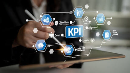 A business professional uses a digital tablet to analyze key performance indicators (KPI) while discussing goals and objectives for effective strategy alignment and performance tracking. Tessel