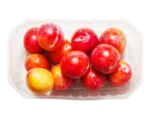 Fresh pure nectarine with glossy skin in a plastic basket on white background. Agriculture product ready to eat and for sale. Food chain supply. Clean ripe organic product carefully selected.