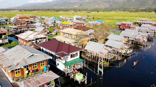 Aerial view of stilt houses in inle lake, myanmar, with mountains in background