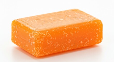 A close-up shot of a rectangular bar of orange soap, isolated.