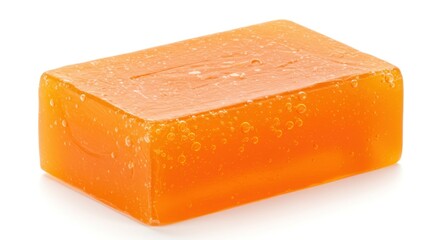 A single bar of orange soap sits on a white surface, casting a soft shadow.