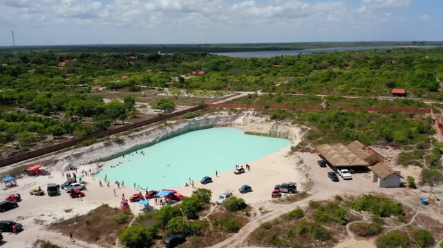 Aerial view of lagoa do paraso with people swimming and cars parked around it