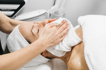 Woman receiving RF lifting treatment for facial rejuvenation, relaxing on treatment bed with soothing ambiance, showcasing advanced skincare technology and professional care