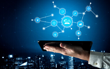 A hand holds a tablet displaying various digital network icons symbolizing communication and data...