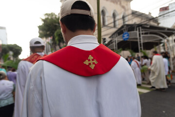 Obraz premium Palm Sunday procession is seen with Catholic faithful participating and walking through the streets of Salvador, Brazil.