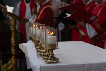 Archbishop and priests are celebrating Palm Sunday Mass during a rainy day.