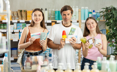 In sales area of drugstore, family customer purchased large number of different goods, items. Hair care products, French body care cosmetic, pills and medicines are in drug store assortment