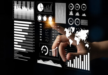 A hand interacting with a digital dashboard displays various graphs and charts, representing data analysis and business intelligence in a modern workspace setup. Impute