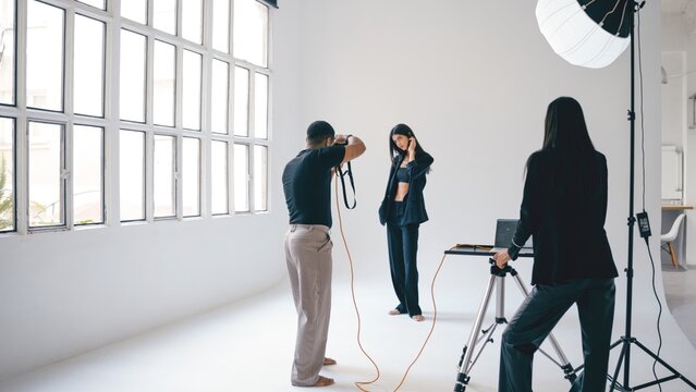 Photographer taking pictures of fashion model in professional studio - Powered by Adobe