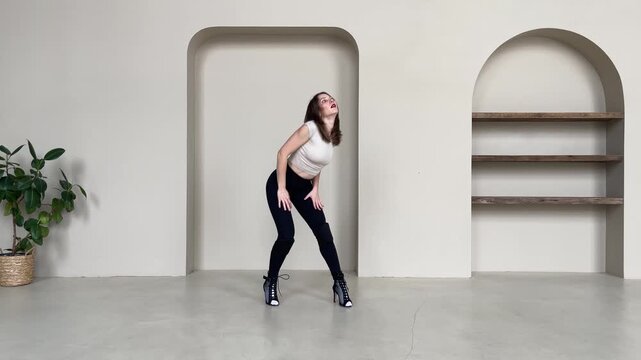 Elegant Woman Dancing in High Heels in Bright Studio