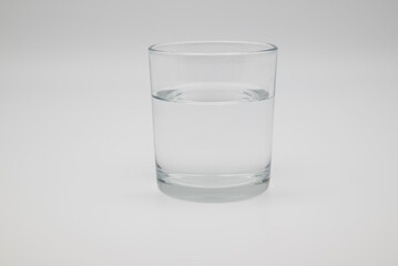 Clear glass of fresh water on white background. Concept of hydration, healthy lifestyle, mental health, nutrition, self-care, and medical wellness.