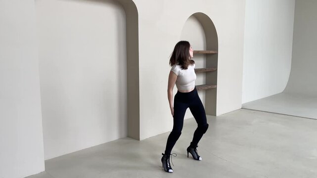 Elegant Woman Dancing in High Heels in Bright Studio