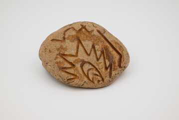 Stones on white background with one carved petroglyph-like rock. Symbol of ancient art, archaeology, cultural heritage, history, and human creativity.