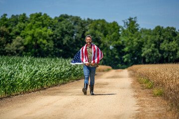 Man with American flag in crop field. Independence day of America. 4th July. American labor day. American flag and man farmer. Flag of USA. Independence day. Man in field. Fourth celebration