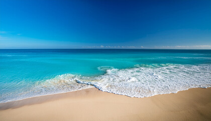 Fototapeta premium A Beach With A Blue Ocean And A Sandy Shore