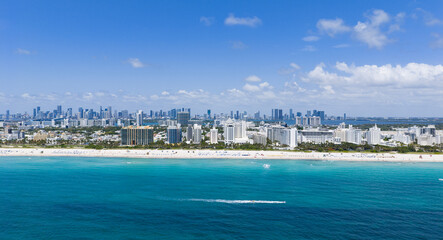 Drone aerial view of Miami sandy beach. Wide drone shot of Miami Beach and ocean waves. Miami beachscape captured from above. Oceanfront Miami resorts by drone.