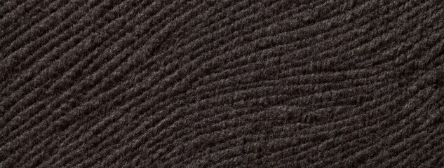 Dark brown background from soft fluffy textile material macro. Texture of plush fabric backdrop. Wavy pattern