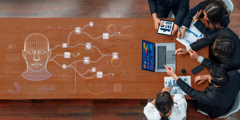 Diverse professionals gather around a table engaged in a business meeting focused on data analysis and artificial intelligence concepts, utilizing modern technology. Trope