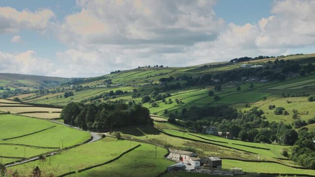 Rolling green hills and farmland stretch across a valley under a cloudy sky - Powered by Adobe