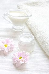 cream and spa on wooden background with flowers