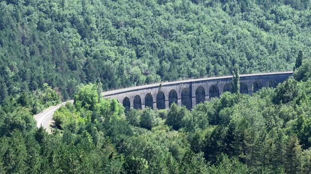 Majestic viaduct curves through lush green valley
