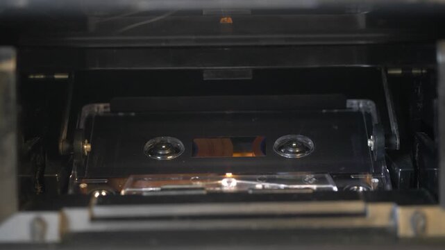 Vintage audio cassette tape playing in a retro deck recorder