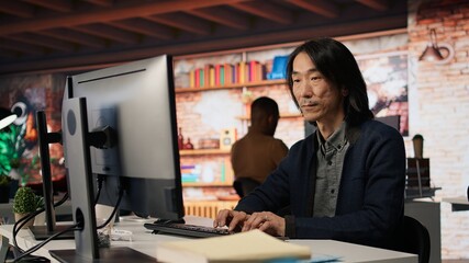 Startup manager leveraging machine learning technology in office to gain competitive edge. Asian Silicon Valley company IT expert working on rapid technological advancement, camera A