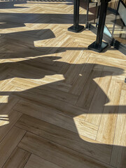 Wooden herringbone floor with shadows in sunlight