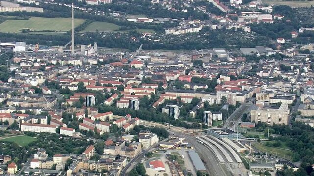 Aerial view of a city with redroofed buildings and a railway station