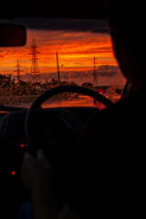 view from a car on the highway in bad weather conditions, rain and fog, at a beautiful red sunset