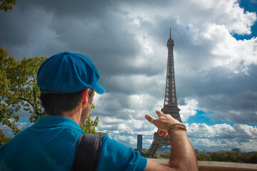 Turista disfrutando de la Torre Eiffel en París, con boina azul parisina y sonrisa alegre. © ismel leal