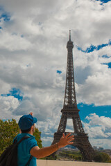 Turista disfrutando de la Torre Eiffel en Par&iacute;s, con boina azul parisina y sonrisa alegre.