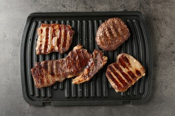 Delicious grilled beef meat on grey table, top view