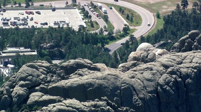 An aerial view shows a parking lot and road near mount rushmore