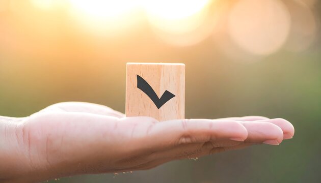 子どもの手に載るチェックマーク木製ブロックの信頼イメージ